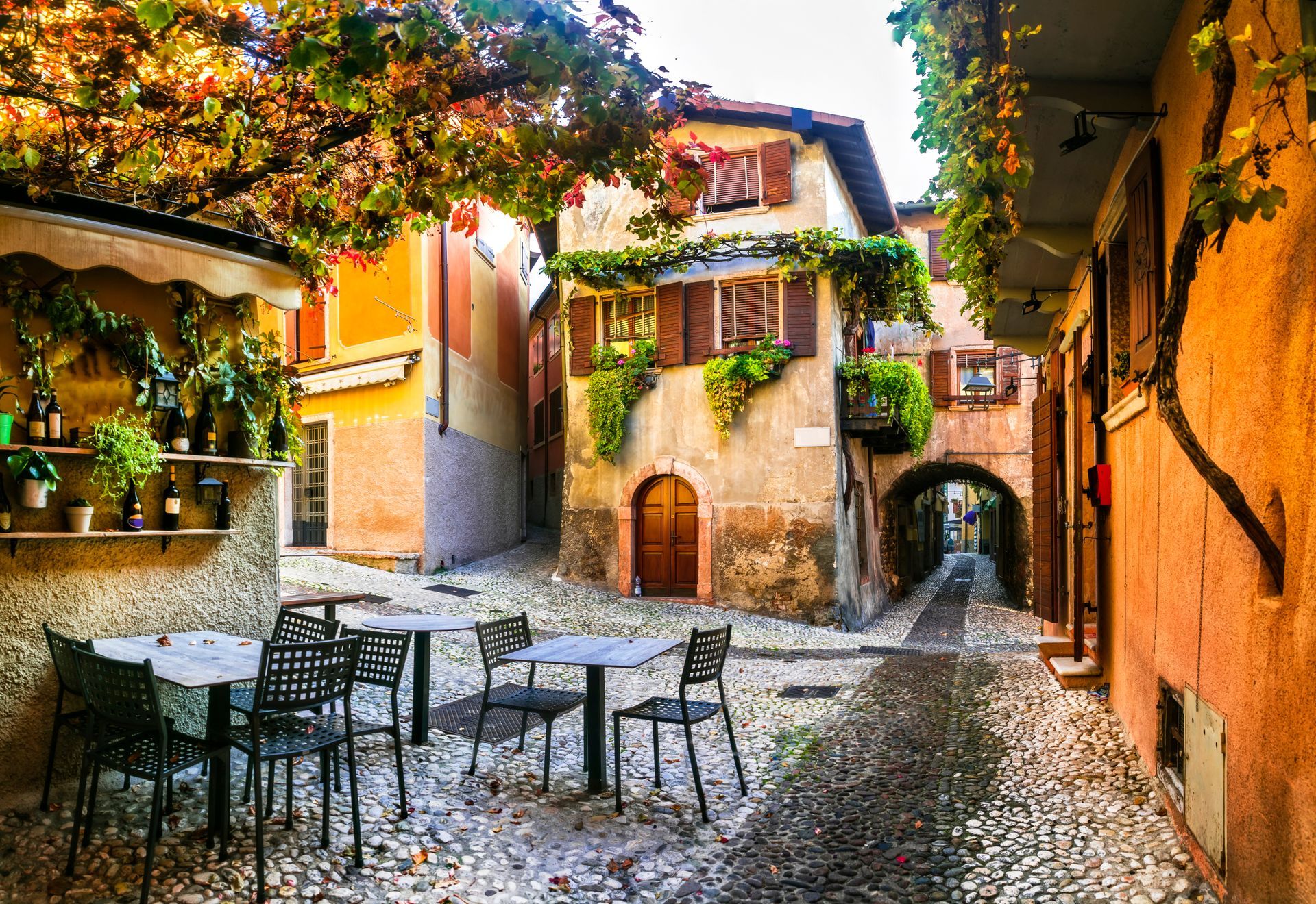 Charming old narrown streets of Italian villages. Malcesine, Garda lake, Italy. Autumn colors, cosy street bars